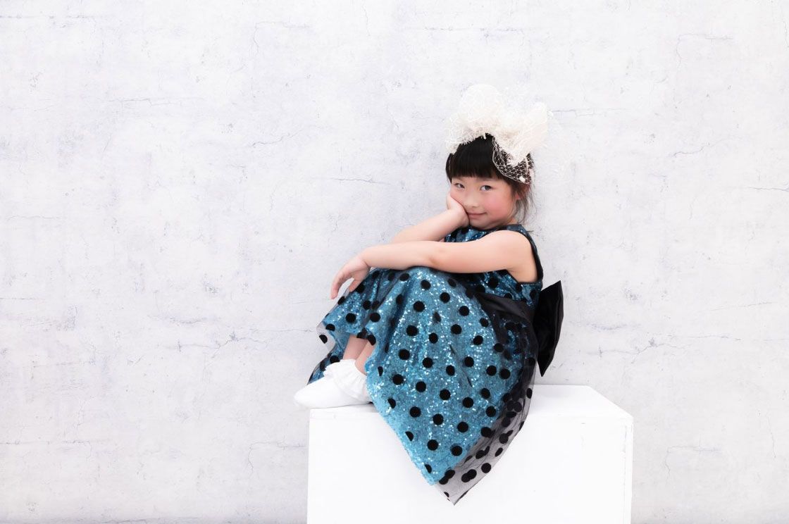 堺東Lulu Studio（ルルスタ）の写真イメージ。女の子がドレスを着て座って微笑んでいる写真。